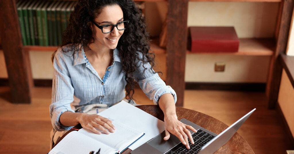 Automated Chatbot Drives 43% Increase In Email Sign-Ups 25 6155ab411472dc47b945ddba portrait of smiling young woman sitting at desk typing on keyboard and using laptop computer