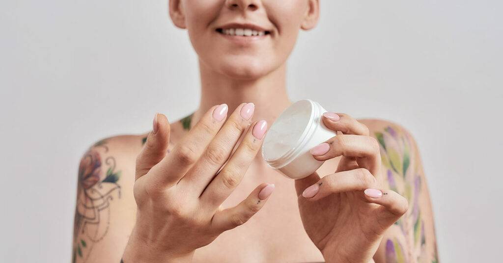 Amazon Lifetime ACoS drops from 45% to 22% and Sales Increase by 56% in 30 days for Skin Care Product 15 6155be320a67d369c9fe2e59 portrait of smiling tattooed woman trying skin care product holding white plastic jar